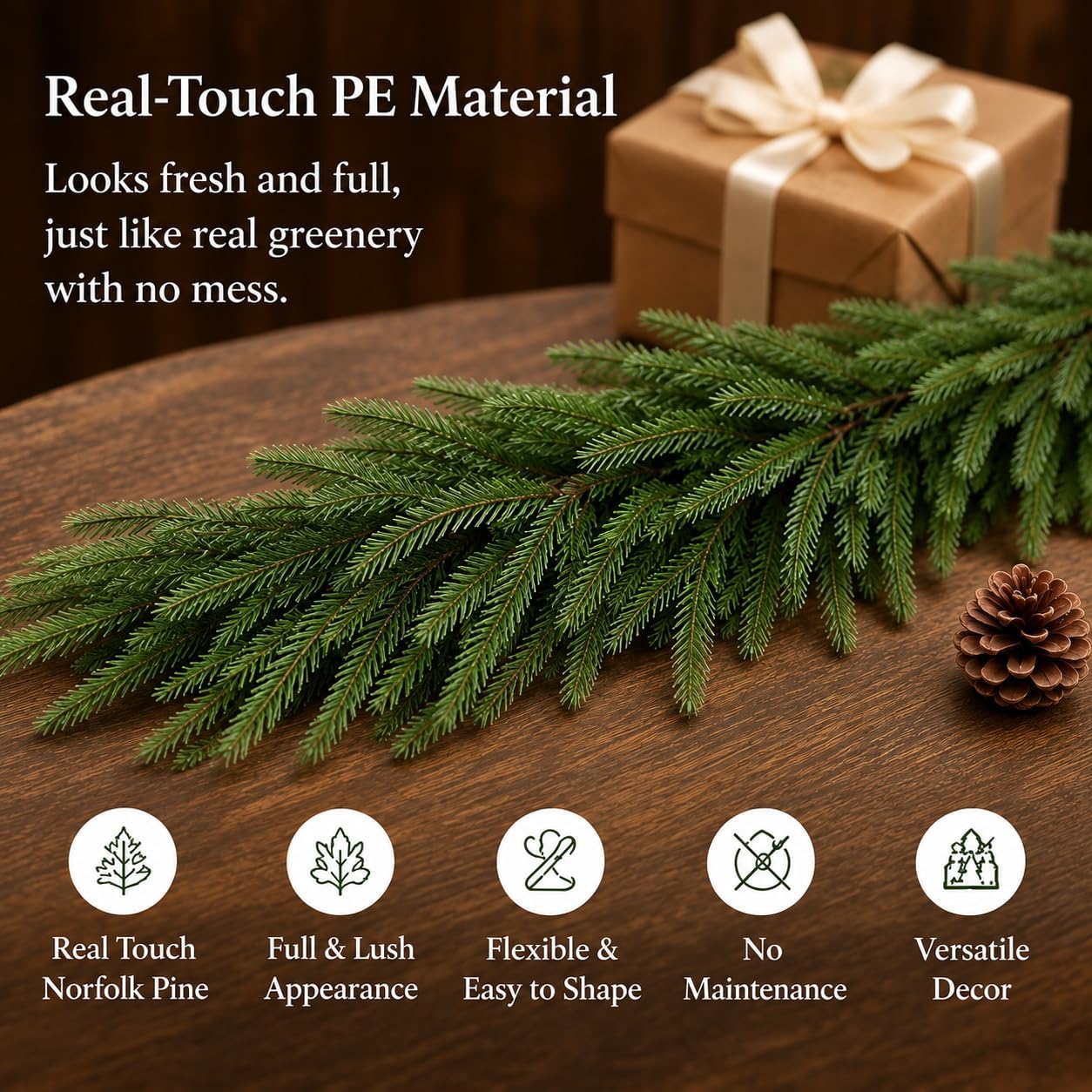 Artificial Norfolk pine garland styled on a wooden table beside a gift and pine cone.