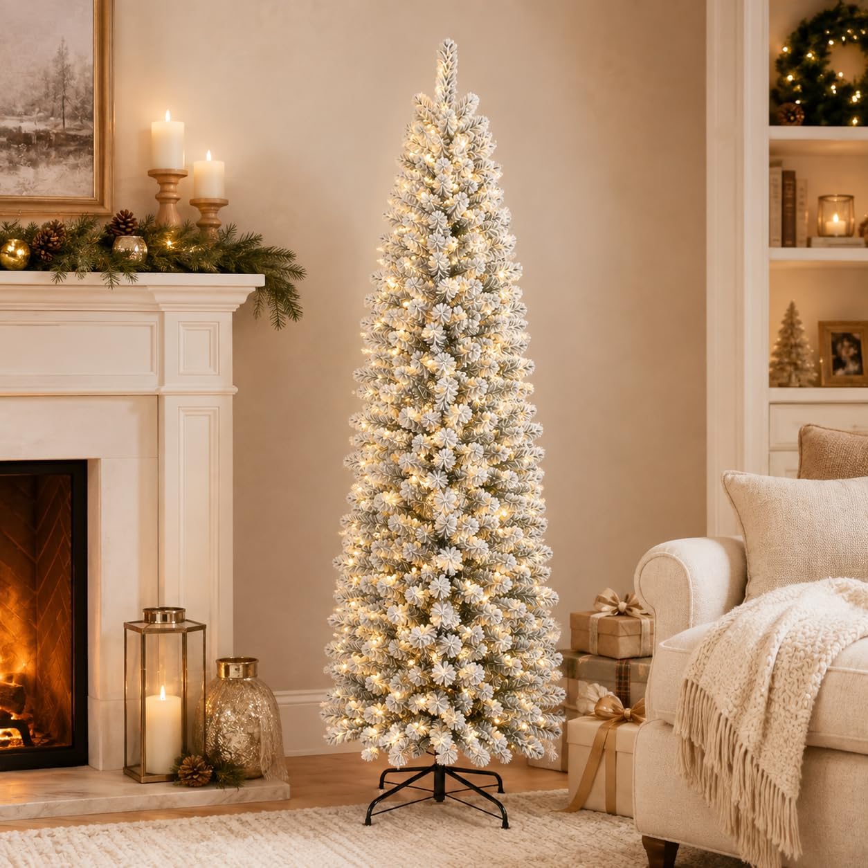 Slim flocked Christmas tree with warm white lights displayed beside a living-room fireplace.